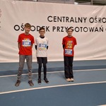 Troje zawodników stoi na tle banneru z napisem Centralny Ośrodek Sportu.jpg