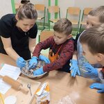 3 chłopców ugniata ciasto_ osoba dorosła im pomaga.jpg