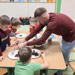 Dorosła osoba pomaga w rozłożeniu masła orzechowego na talerze.jpg