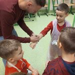 Czterech chłopców stoi przy mężczyźnie_ który rozdaje autografy. .jpg