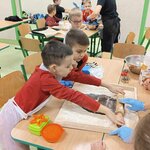 Dwóch chłopców przy stolnicy_ dorosły pomaga.jpg