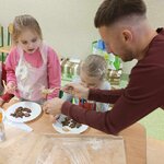 Troje dzieci przy stoliku. Dorosły wykłada ze słoika masło orzechowe do dekoracji .jpg