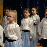 Grupa dzieci w białych bluzkach stoi na tle niebieskiegho parawanu .jpg