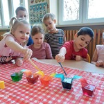 Chłopiec i dziewczynka z gr. Biedronki wlewają barwniki za pomocą pipety zabarwiając wodę na kolorowo..jpg