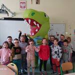 Dzieci z gr. Motylki stojące z dmuchanym dinozaurem..jpg