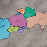 Puzzle: Polska i jej sąsiedzi. Na podłodze ułożone są puzzle. W centrum Polska, wokół kraje sąsiadujące.