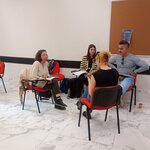 Nauczyciele w czasie zajęć siedzący na krzesłach podczas pracy w grupie i dyskusji o systemach edukacji w Europie.jpg