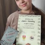 Uczennica trzyma dyplom oraz statuetkę za 2 miejsce w konkursie.jpg