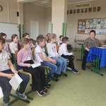 Reprezentanci klas siedzą na krzesłach _ czekają na występ. Po prawej stronie za stołami.jpg