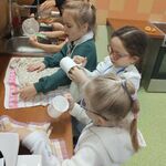 4 stoją przy zlewie  jedna obok drugiej_ zmywają i wycierają naczynia_ w oddali - dorosła osoba .jpg