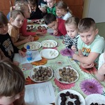 Dzieci siedzą dookoła stołu_ przed nimi różego rodzaju kuleczki mocy.jpg
