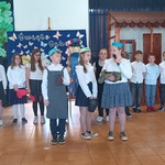 Z przodu trzy dziewczynki_ w tle rzędem stoi duża grupa dzieci.jpg