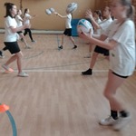 Dziewczęta w parach podają do siebie piłki do rugby.jpg