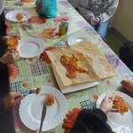 uczniowie jedzą pizzę