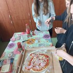 na stolnicy leży surowa pizza