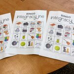 Kolorowe karty do gry w bingo z symbolami czynności leżące na stole i wykorzystane podczas warsztatów.jpg