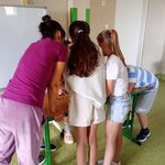Grupa uczniów i nauczyciel podczas pracy w grupie_ próbujący narysować obrazek bez użycia rąk..jpg