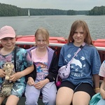 Pięć dziewczynek siedzi z tyłu statku_ w tle widok na jezioro.jpg