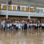 Zdjęcie przedstawia uczniów edukacji wczesnoszkolnej stojących w rzędach na prakiecie sali.jpg