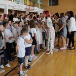 Zdjęcie przedstawia uczniów klas pierwszych stojących w rzędach na sali gimnastycznej. Prz.jpg