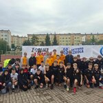 Grupa chłopców stojących przed banerem programu Aktywnej Szkoły podczas turnieju piłki nożnej.