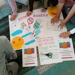 Na zdjęciu dzieci przykładają dłonie do plakatu_ podkreślając swój udział w jego tworzeniu.jpg