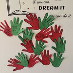 Na białych drzwiach znajduje się dekoracja z czerwonymi i zielonymi papierowymi odrysami dłoni, na których uczniowie wypisali hasła i pomysły związane z przeciwdziałaniem przemocy.