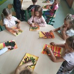 Dzieci z grupy Motylki siedzące przy stolikach i wykonujące pracę plastyczną Jesienne drzewko..jpg