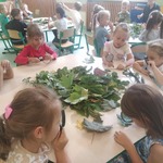 Dzieci z grupy Motylki siedzące przy stolikach i oglądające przez lupy jesienne liście..jpg