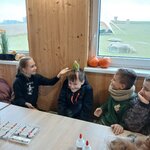 Papuga siedzi na głowie ucznia_ dziewczynka wyciąga rękę_ aby papuga usiadła na niej. Chło.jpg