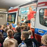 Uczniowie przyglądają się wnętrzu karetki_ ratownik przygotowuje sprzęt do pokazania..jpg