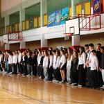Duża grupa uczniów podczas śpiewania hymnu na hali sportowej.JPG