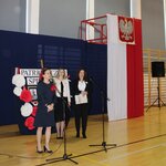 Pani Dyrektor przemawia_ z tyłu widać dwie kobiety_ w tle biało czerwne płótno z godłem.JPG