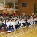 Z przodu na ławeczkach siedzą młodsze dzieci_ z tyłu widać harcerzy.JPG