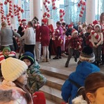Dzieci w foyer opery_ widoczne są duże biało-czerwone maskotki w kształcie cukrowych lasek.jpg
