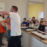 Mężczyzna na specjalnym haku na ścianie roziąga porcję karmelu.jpg