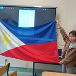 Kobieta i dziewczynka trzymają flagę Filipin_ obok stoi mężczyzna.jpg