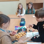 Dziewczynka częstuje kolegów azjatyckimi ciasteczkami kokosowymi.jpg