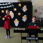 Dziewczynka gra na keyboardzie druga stoi z mikrofonem.jpg
