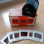 zdjęcie podręcznego rzutnika obok kilku slajdów w ramkach i pudełeczka z napisem w języku rosyjskim.jpg