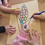  Zdjęcie przedstawia rysunek hiacynta na jasnym papierze, wypełniony wieloma różnokolorowymi uśmiechniętymi buźkami, stworzony wspólnie przez dzieci jako podsumowanie zajęć.