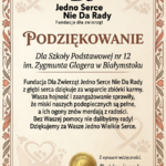 Ozdobny certyfikat z podziękowaniem na kremowym tle, z motywami serc i psich łapek. Na górze logo fundacji z sylwetkami psa i kota. Tekst podziękowania skierowany jest do Szkoły Podstawowej nr 12 im. Zygmunta Glogera w Białymstoku za pomoc w napełnieniu misek podopiecznych fundacji. Dokument jest opatrzony datą 20.03.2026 r., złotą pieczęcią oraz podpisem prezes zarządu, Magdaleny Smosarskiej.