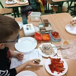 Na stole stoją talerze z przekąskami pokrojona papryka_ marchewki_ pomidorki oraz miska z .jpg