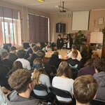 Zdjęcie przedstawia jasne wnętrze dużej sali przypominającej salę lekcyjną w placówce edukacyjnej. Układ pomieszczenia wskazuje na zorganizowane spotkanie, prezentację lub wydarzenie grupowe.