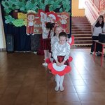 Uczennice tańczą z rekwizytami biało-czerwonymi na tle tablicy z napisem KOCHAM CIĘ POLSK.jpg