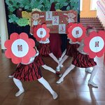Uczennice tańczą z rekwizytami imitującymi biało-czerwone kwiaty..jpg