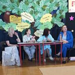 Jury siedzi przy stole na szkolnej sali_ za nimi dekoracja z papierowego drzewa z hasłami .jpg