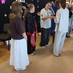 Uczestnicy stoją w kolejce przed czarną ścianką „FINAL MAM TALENT”_ jedna osoba otrzymuje .jpg