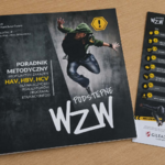 Na drewnianym blacie leżą dwa materiały edukacyjne dotyczące profilaktyki zakażeń HAV, HBV i HCV. Po lewej stronie znajduje się  ciemna broszura  z grafiką skaczącej  osoby w zielonej bluzie oraz dużym napisem 