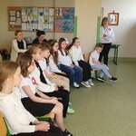 Dzieci siedzą w rzędzie na krzesłach.jpg